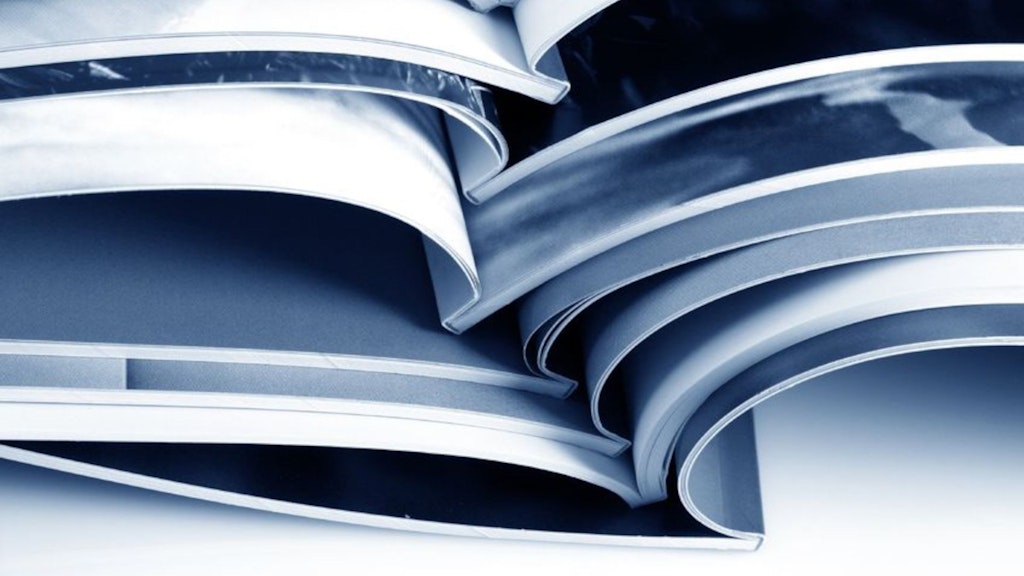 Mehrere aufgeschlagene Hefte liegen auf einander. Die Fotografie ist in verschiedenen Grautönen gehalten.