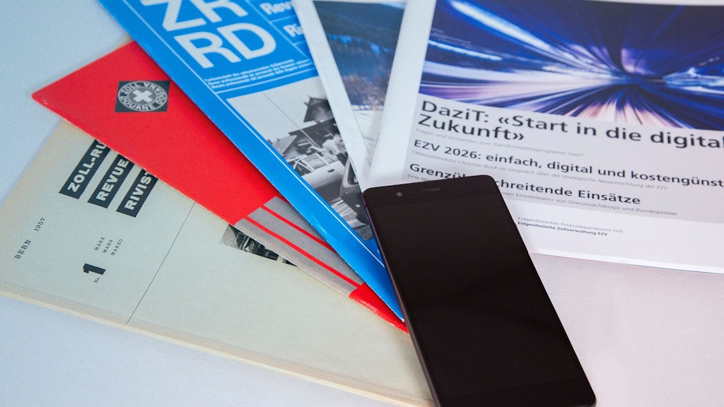 The image shows various editions of the Customs Review and Forum D. and a smartphone. One edition discusses the DaziT program and the digital transformation of the Federal Customs Administration.