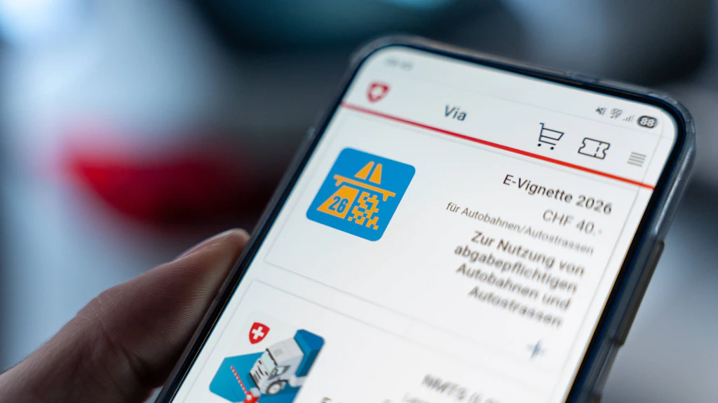 Un smartphone affiche l'e-vignette suisse 2026 dans une application. La vignette est nécessaire pour l'utilisation des autoroutes et des routes nationales. Le prix de CHF 40 est visible.