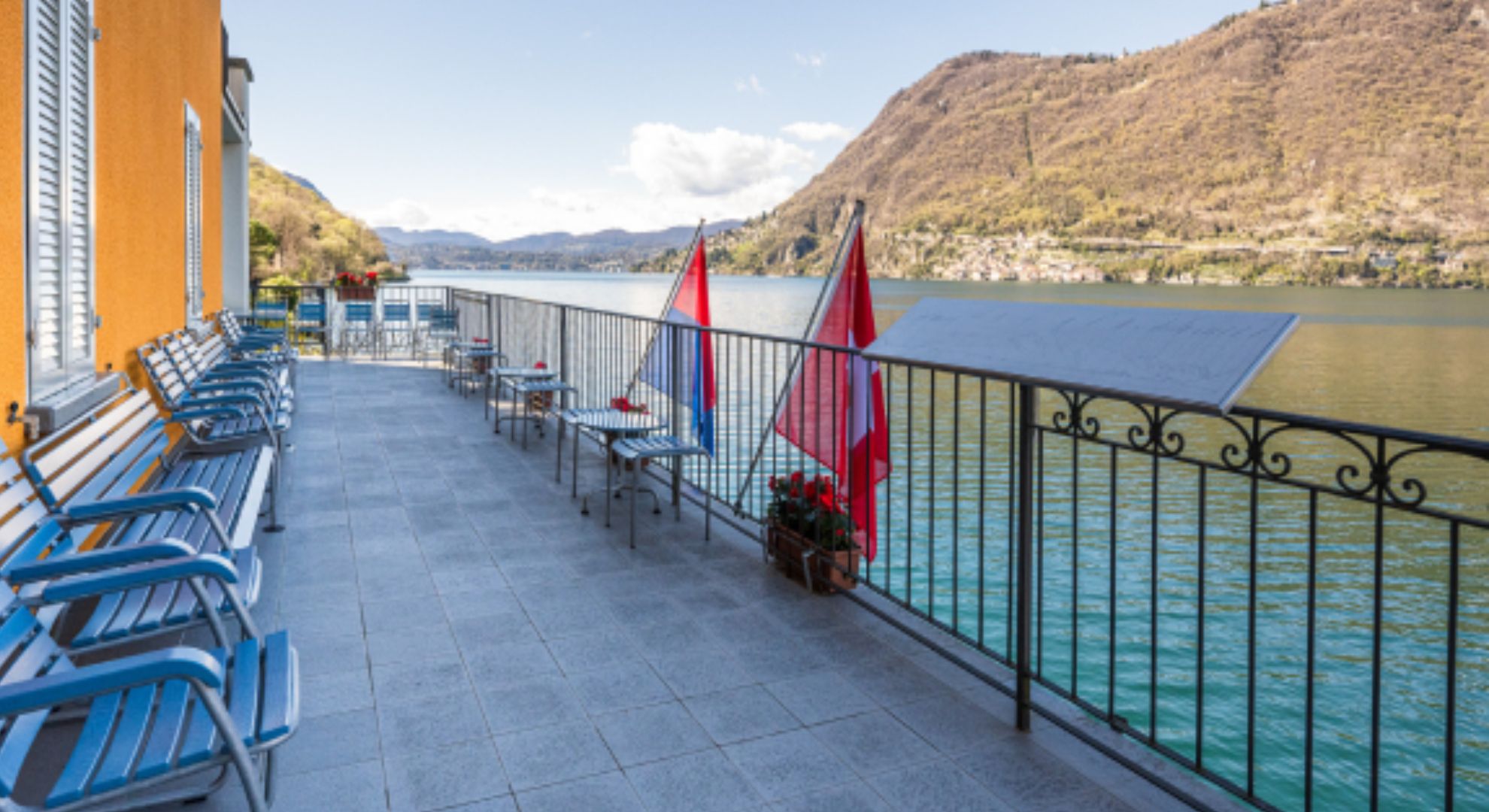 Terrasse des Schweizer Zollmu-seum. Auf der Terrasse sind zahl-reiche blaue Bänke, Stühle und Tische zu sehen.