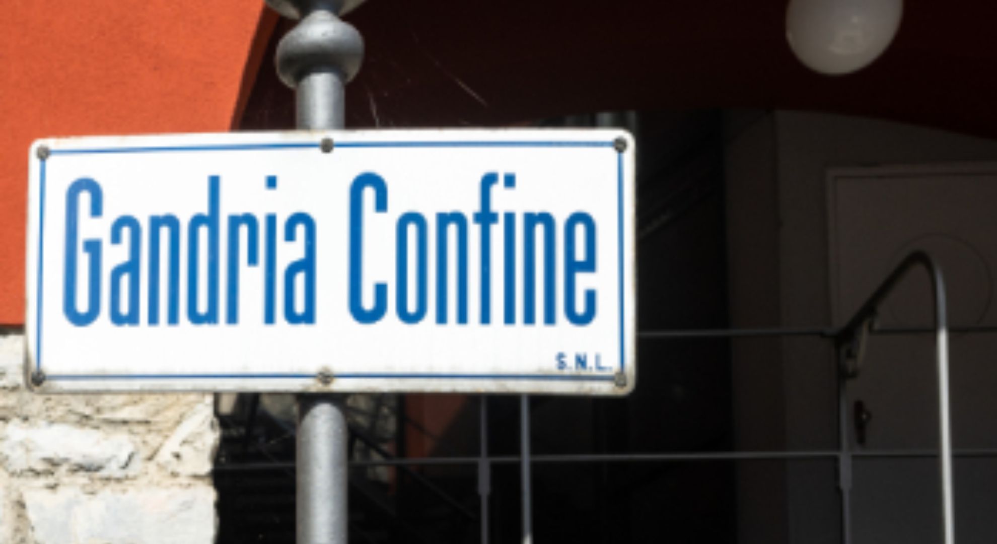 Weisses Strassenschild mit blauer Aufschrift "Gandria Confine"