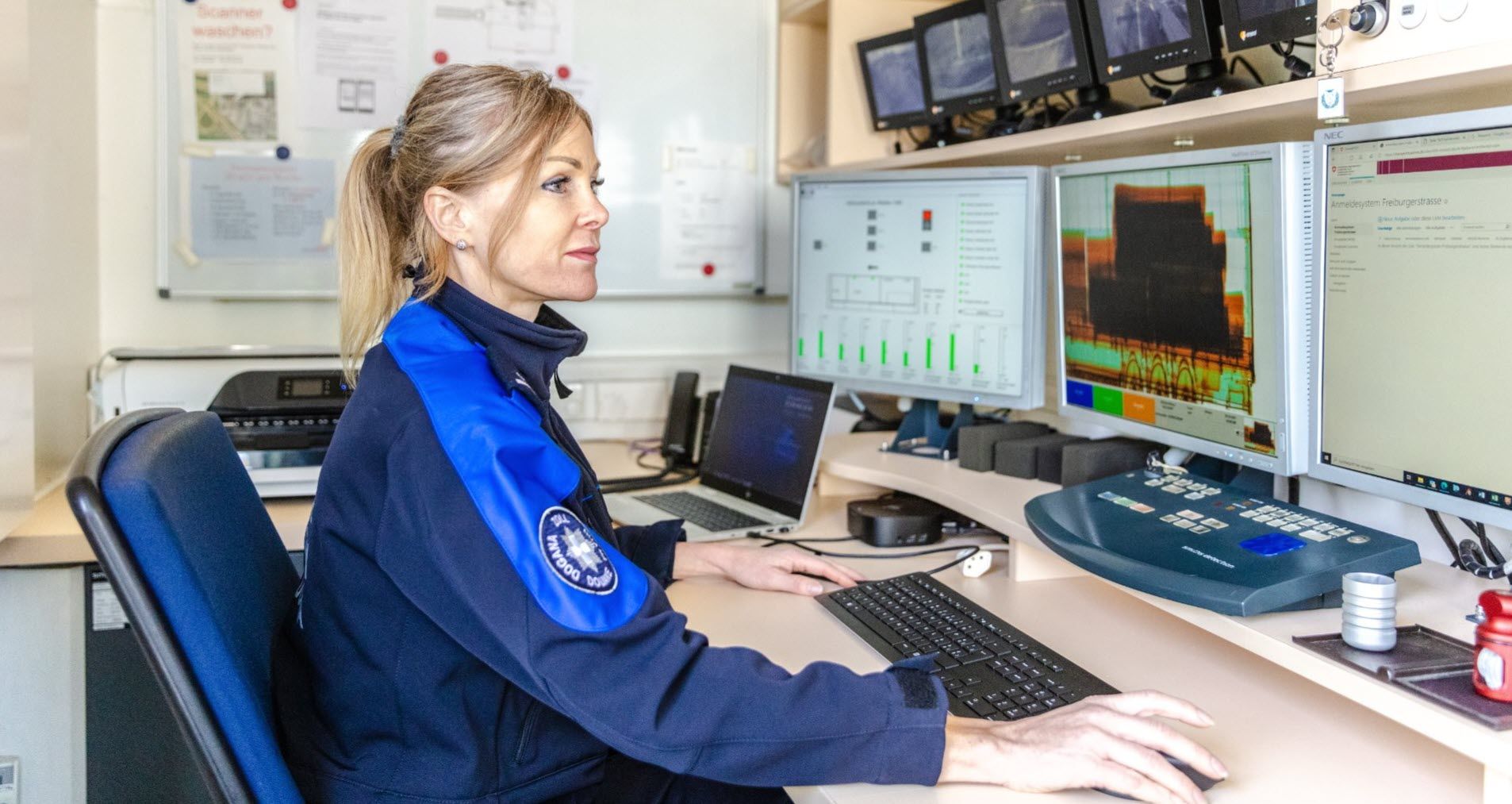 Mitarbeiterin des Zoll beurteilt Daten an Bildschirmen