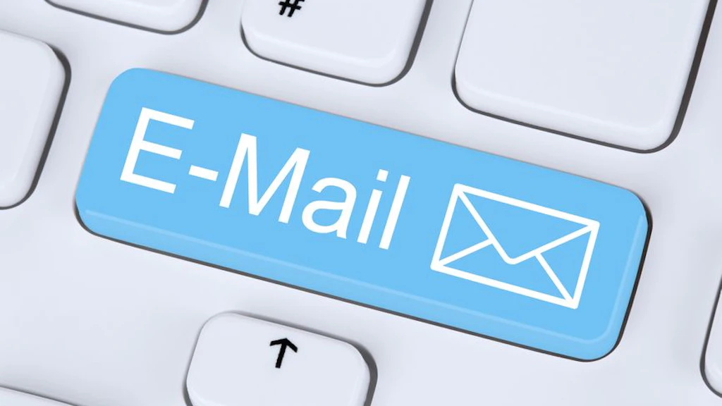 Eine weisse Computertastatur mit einer auffälligen blauen Taste, auf der „E-Mail“ und ein Briefsymbol abgebildet sind. Die Taste steht sinnbildlich für elektronische Kommunikation oder Newsletter-Anmeldung.