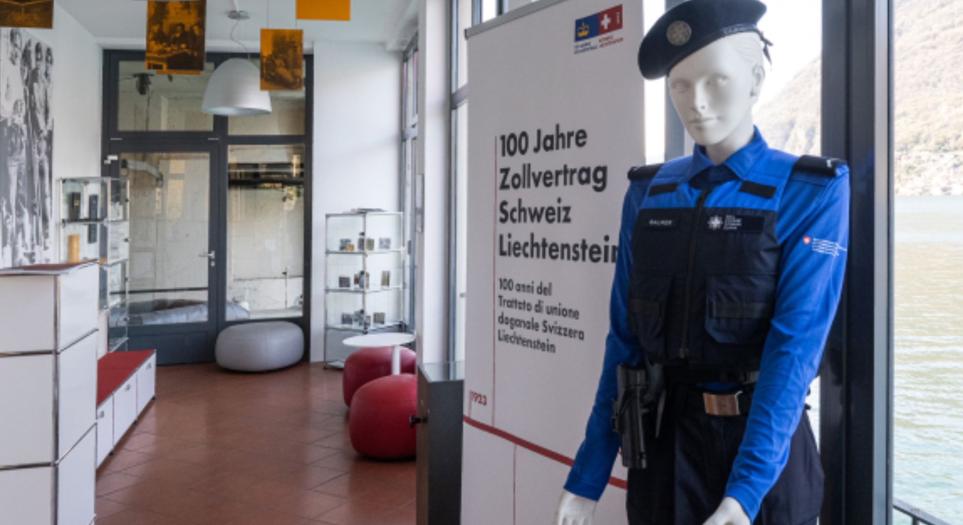 Schaufensterpuppe mit Zoll Uni-form vor einem Plakat der "Ausstellung 100 Jahre Zollvertrag Schweiz Liechtenstein"