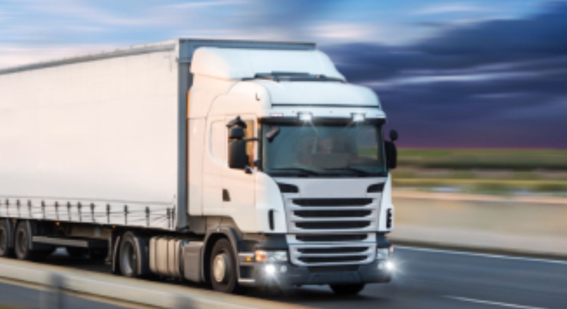 weisser Lastwagen fährt auf der Autobahn