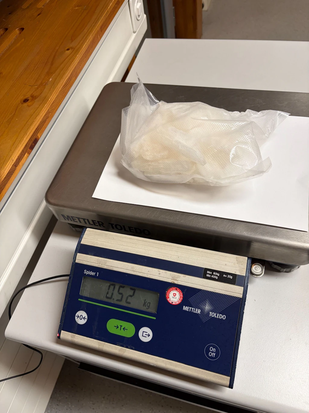 Ein vakuumiertes Päckchen mit weissem Pulver liegt auf einer Waage. Das Display der Waage zeigt 0.52 kg an. Es handelt sich vermutlich um Amphetamin. 