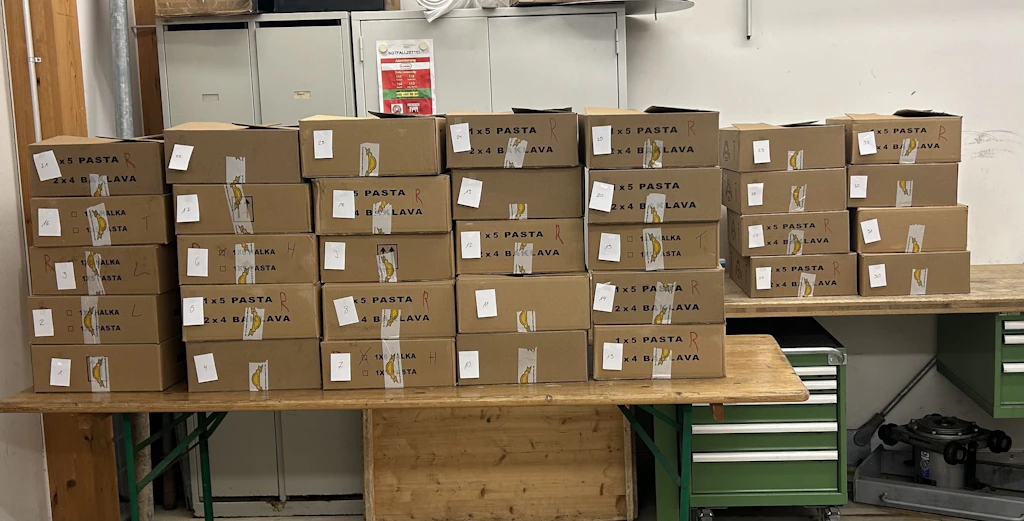 Gestapelte Kartons mit Baklava und Pasta in einem Lagerraum, nummeriert und für die Kontrolle vorbereitet.  