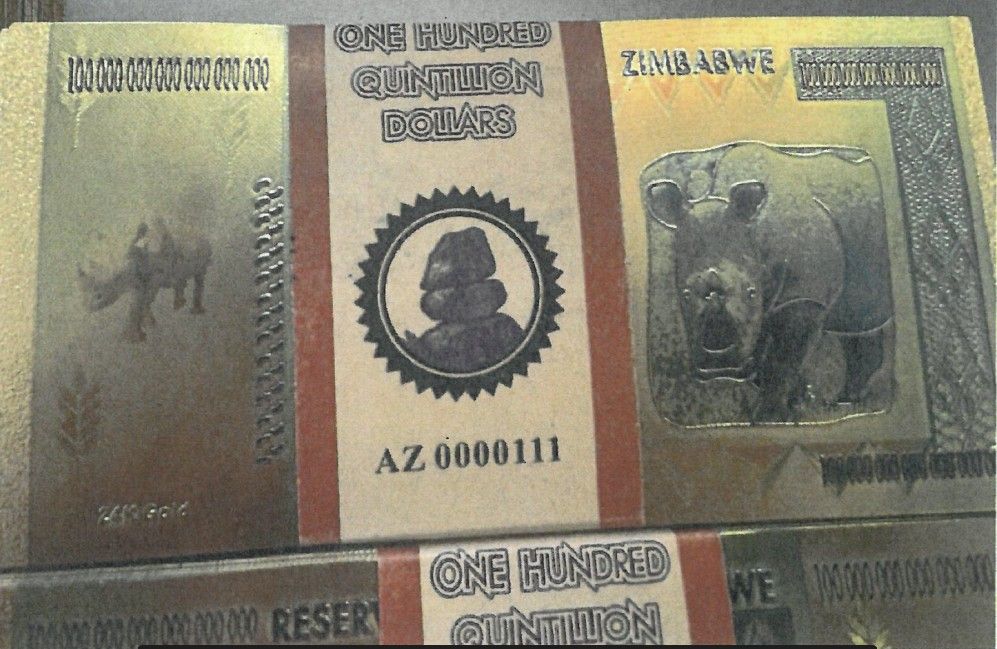 Abgebildet sind angebliche Goldbanknoten aus Simbabwe mit der Aufschrift „One Hundred Quintillion Dollars“. Die Noten zeigen Tiermotive und glänzende Sicherheitsmerkmale, entpuppen sich jedoch als Fälschungen.