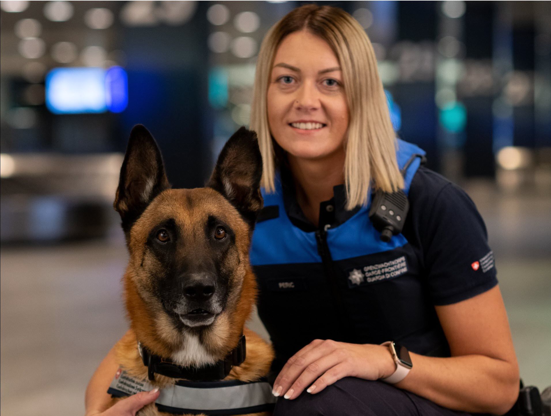 Eine Diensthundeführerin posiert mit ihrem Hund.