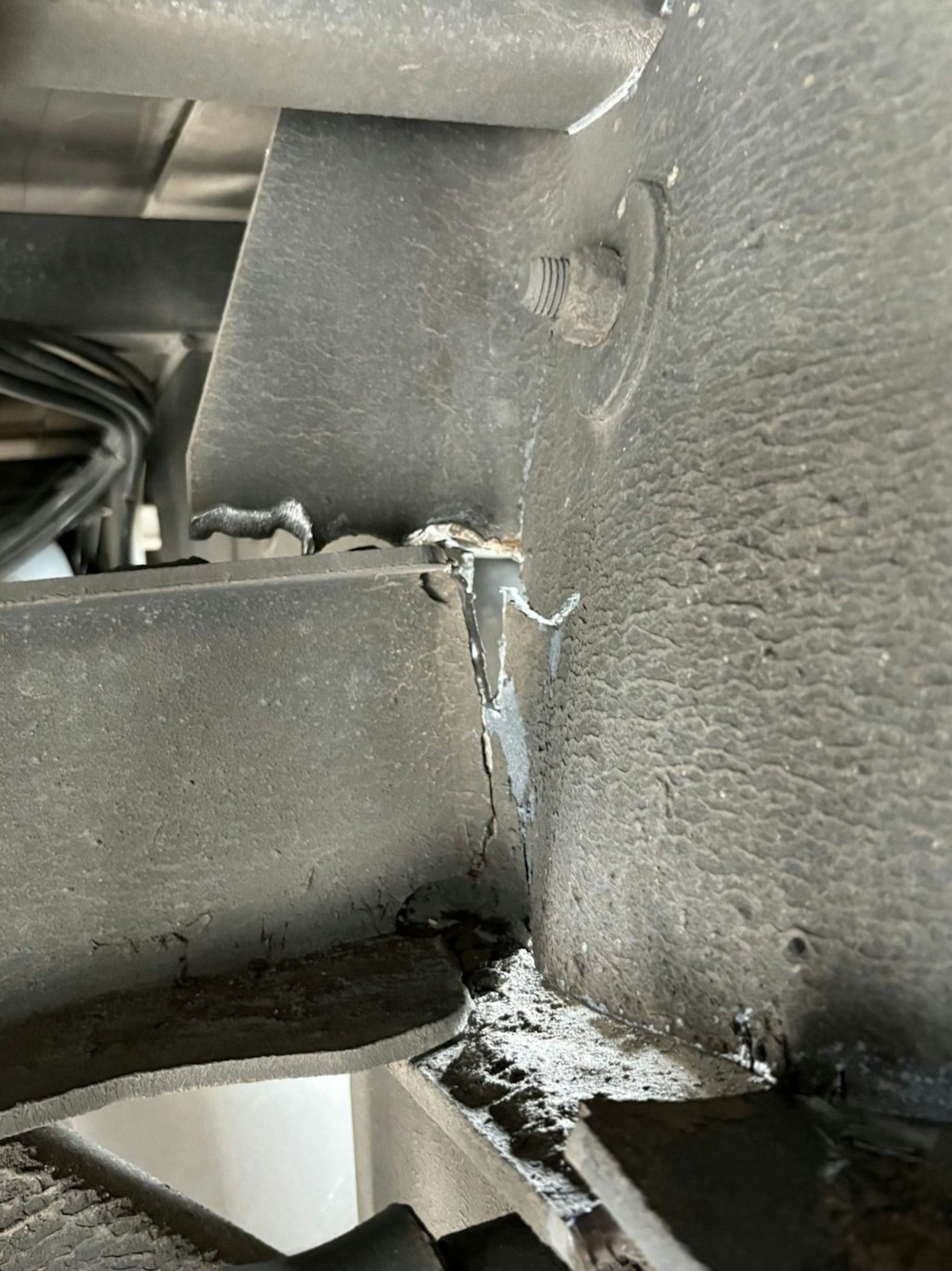 Ein deutlicher Riss im Chassis eines Fahrzeugs ist sichtbar. Der Schaden zeigt eine potenzielle Schwachstelle in der Struktur.