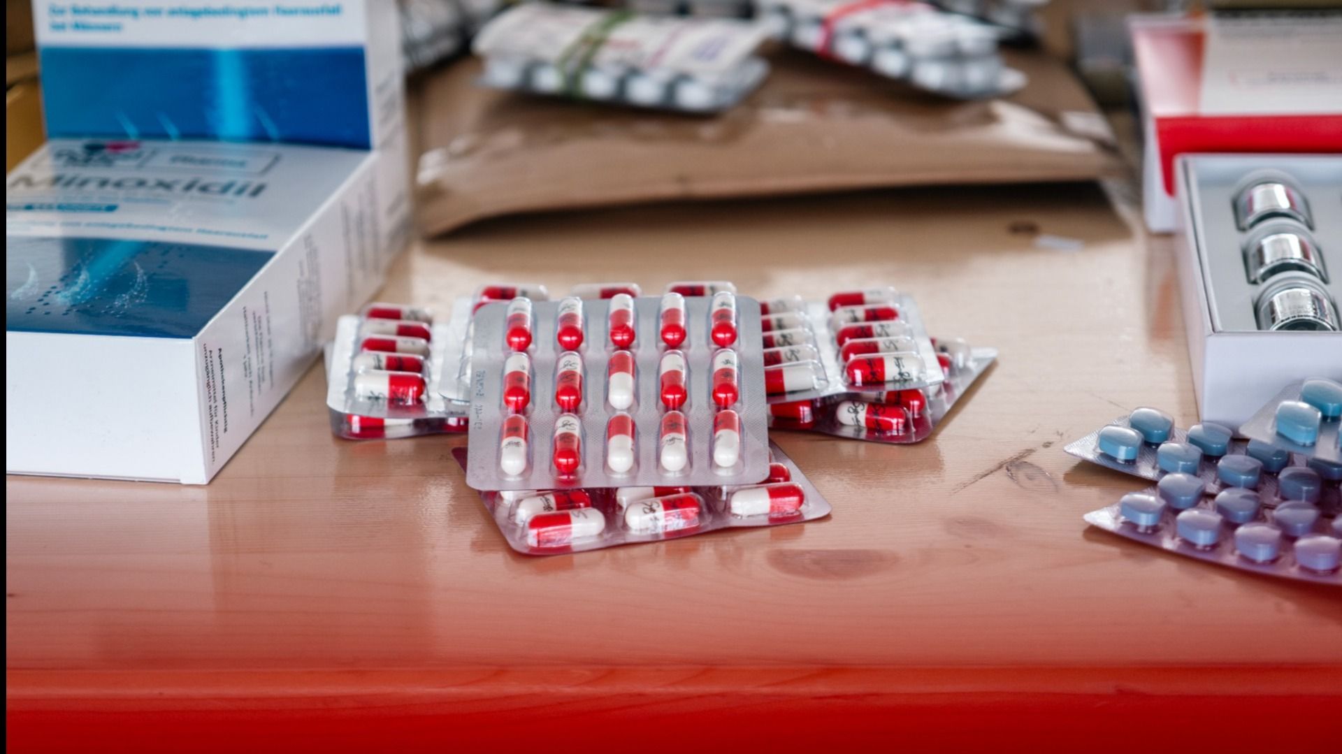 Various drugs in blister packs and boxes on a table. These may have been seized by the FOCBS.