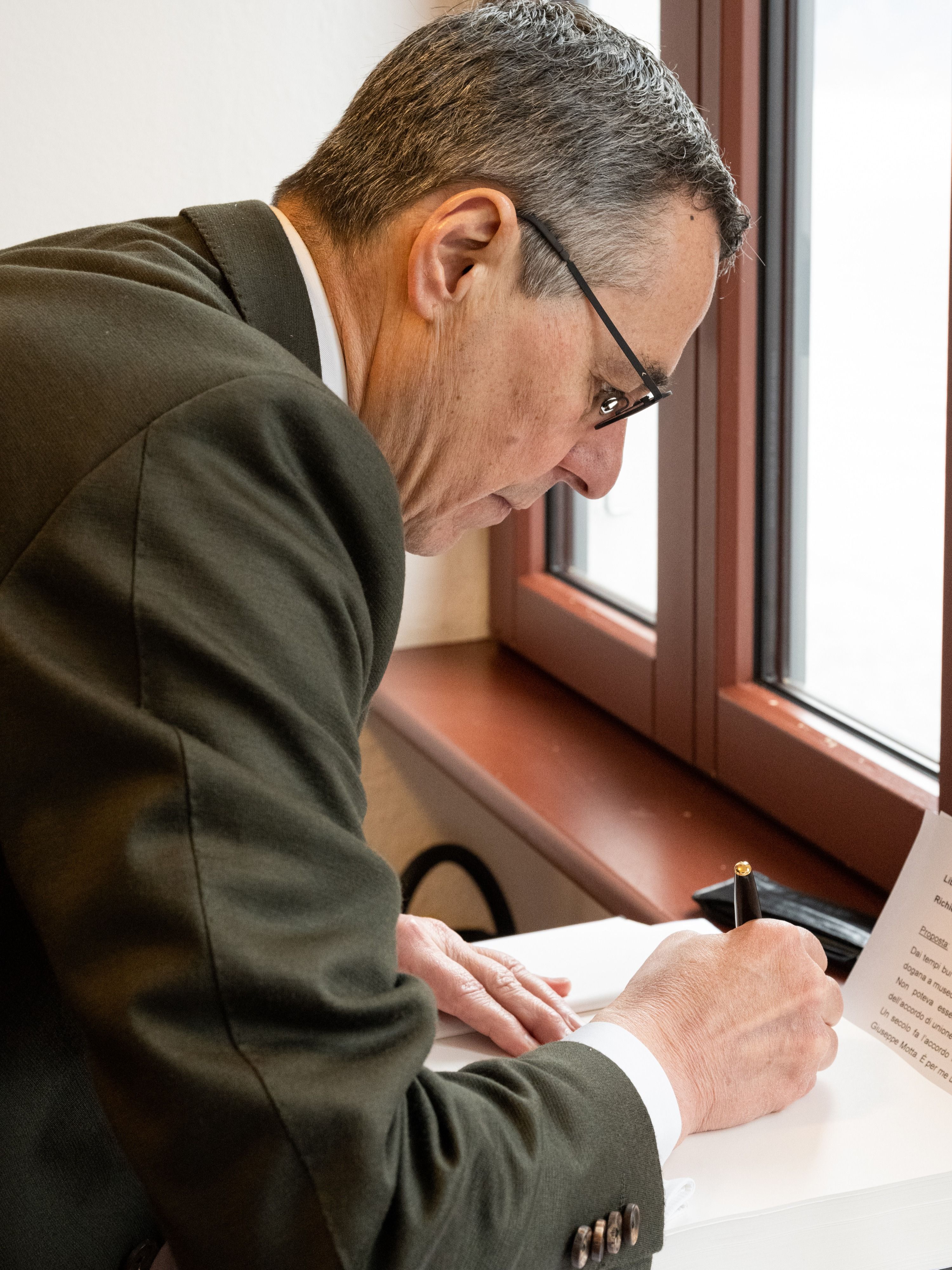 Le conseiller fédéral Cassis signe un document.