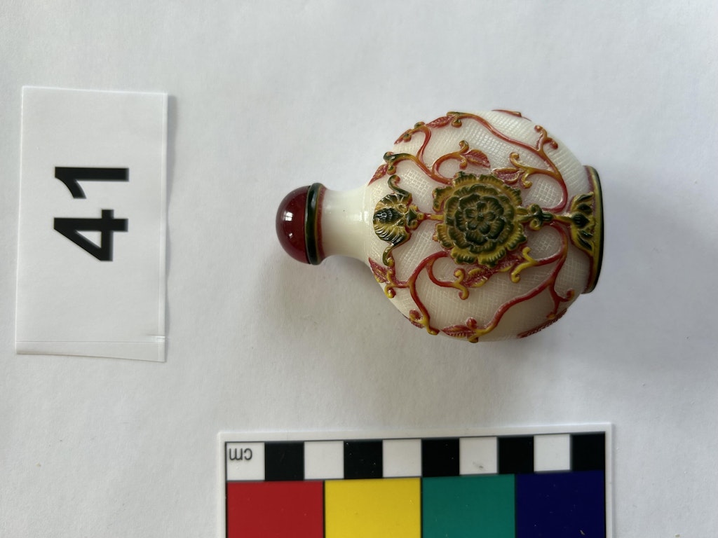 Une tabatière richement ornée avec des motifs floraux et des accents rouges. La tabatière date du 19e ou 20e siècle.