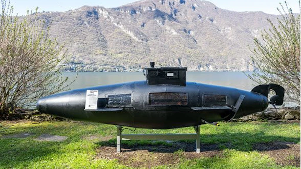 Un sottomarino ricostruito è esposto all'aperto davanti a un paesaggio montano. Fa parte di un'esposizione speciale al museo doganale svizzero.