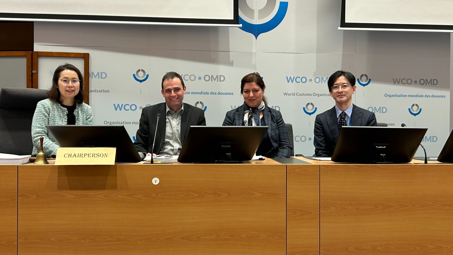 Quattro persone sedute a un tavolo durante una riunione dell'Organizzazione mondiale delle dogane.  
